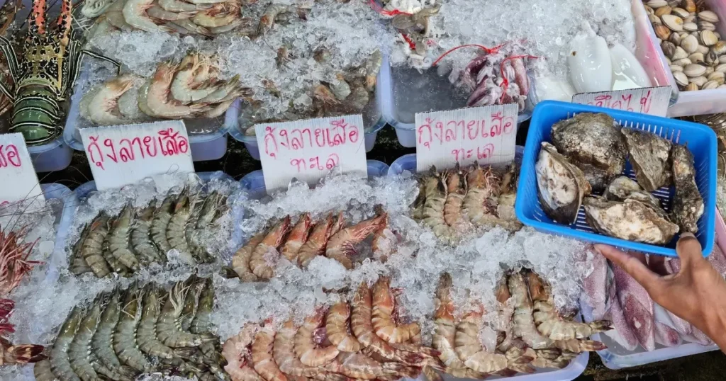 pesce e gamberi esposti su ghiaccio a Rawai in Thailandia, conservazione cibo in Asia